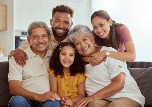 Happy, generations and portrait of big family on sofa for relax, smile and bonging. Happiness, love and grandparents with parents and child in living room at home for free time, weekend and hug